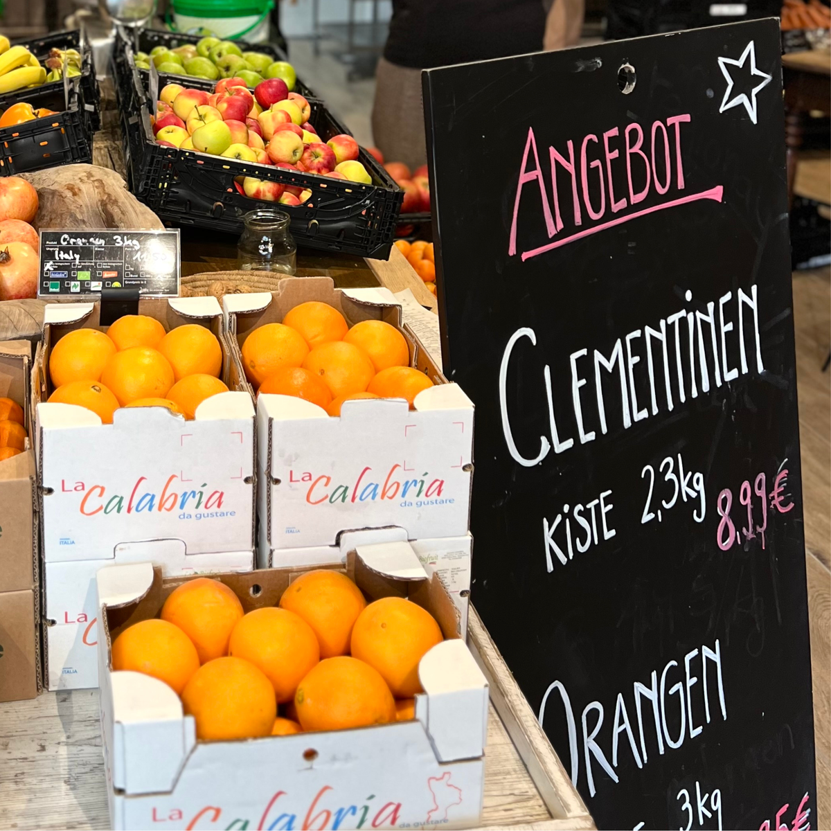Obst im Hofladen mit Angebotsschild und ausgewählten Produkten
