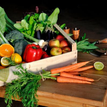 KI generiert: Frisches Obst und Gemüse in einer Holzkiste auf einem Tisch.
