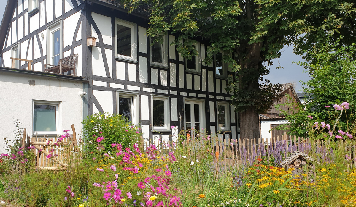 Eingang Hofladen Blumenhof in Eitorf mit Kundin und Hund – Bio-Einkauf regional