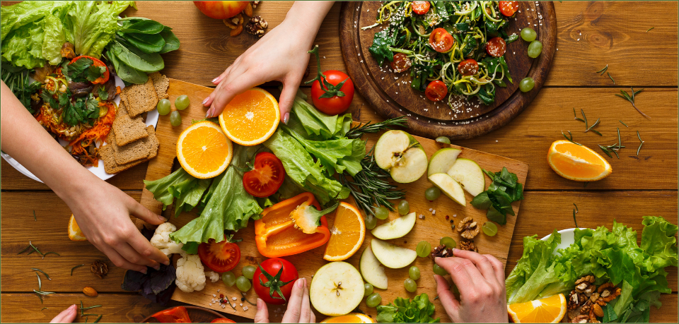 KI generiert: Frische Zutaten und Salat auf Holztisch mit Händen, die Obst und Gemüse arrangieren.