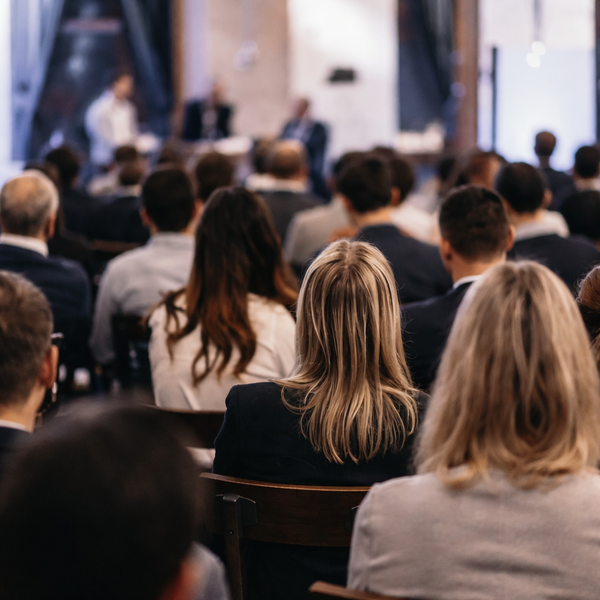 KI generiert: Personen sitzen in einem Konferenzraum, fokussiert auf eine Präsentation oder Diskussion.