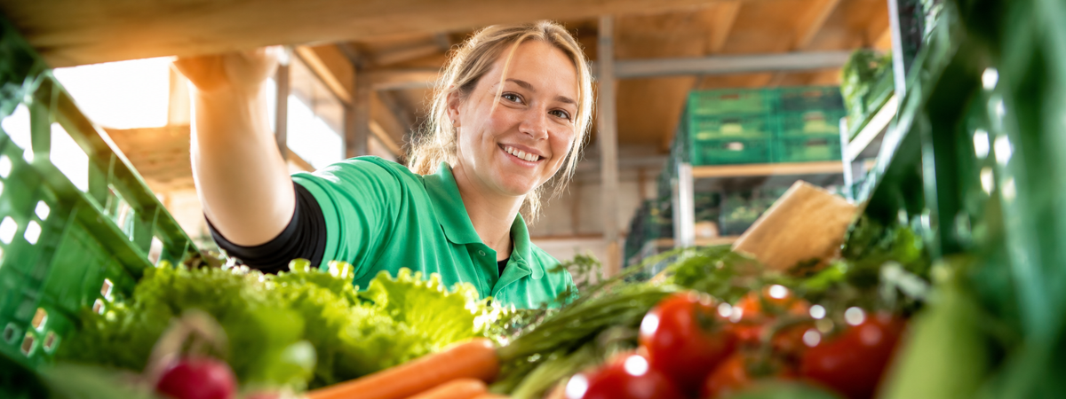 Mitarbeiterin der Hofkiste beim Packen von frischem Bio-Gemüse