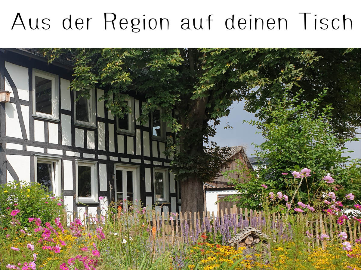 KI generiert: Fachwerkhaus mit bunten Blumen im Vorgarten. Text: "Aus der Region auf deinen Tisch".